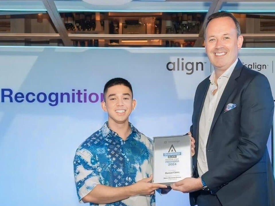 Bác sĩ Hồ Lê Bảo Ân (trái) nhận bảng chứng nhận từ ông David Carr, đại diện Align Technology, trên sân khấu lễ vinh danh